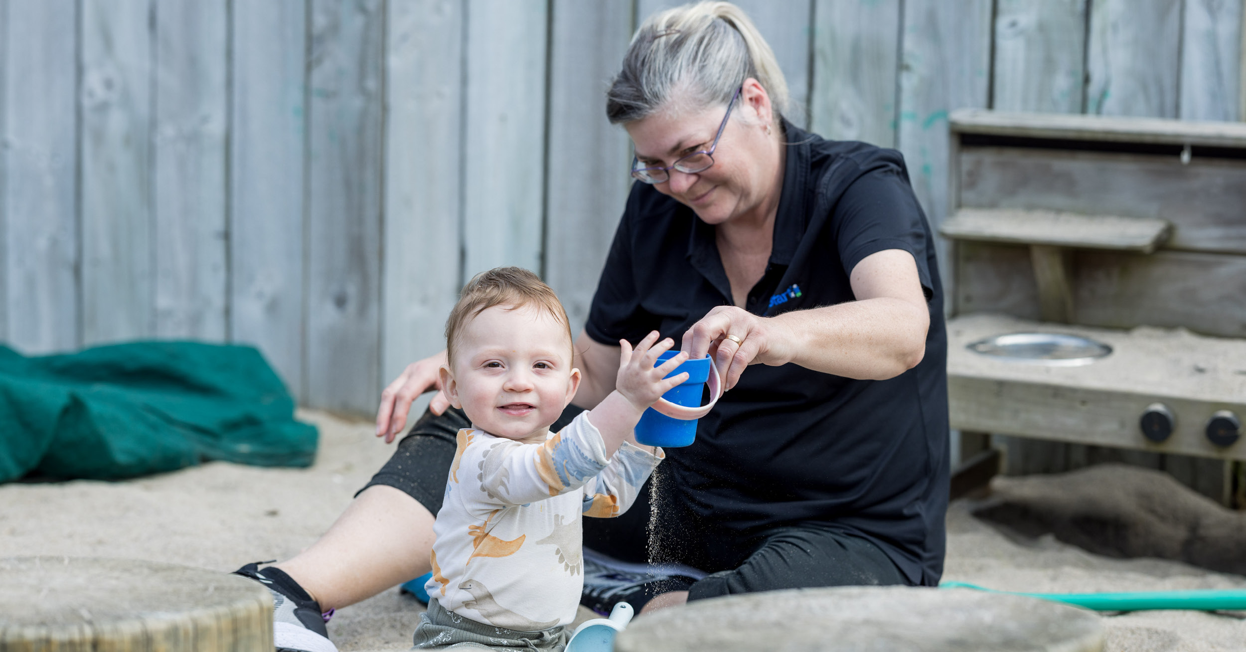 1727728508Teacher and Baby in Sandpit Sept2024.jpg